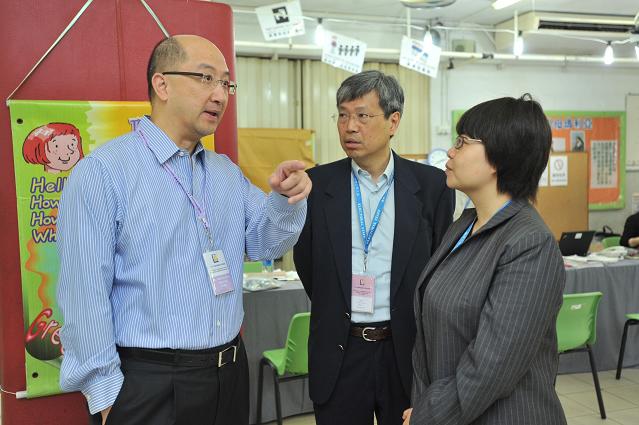 The Secretary for Constitutional and Mainland Affairs, Mr Raymond Tam, visits the polling station for the Kwun Tong District Council Ping Shek Constituency by-election set up at the Ping Shek Estate Catholic Primary School, Ping Shek Estate, this morning (May 26). Photo shows Mr Tam (first left) chatting with polling station officers.
